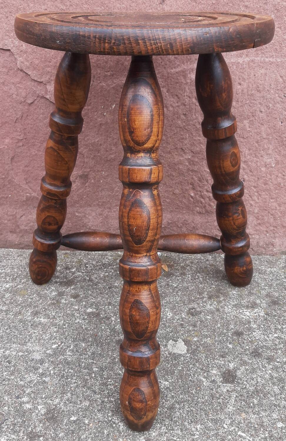 Low wooden tripod stool.