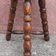 Low wooden tripod stool.
