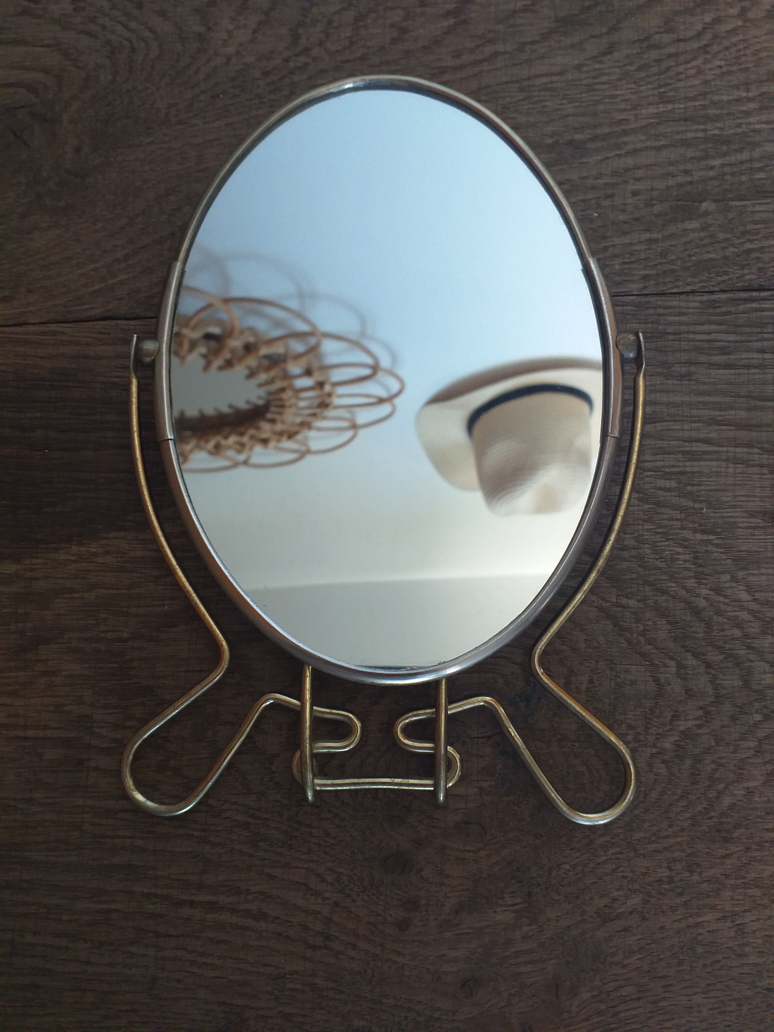 Vintage oval mirror on suspended stand