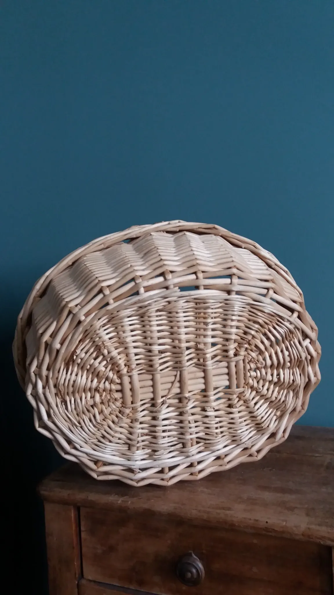 Handcrafted wicker basket with a handle.