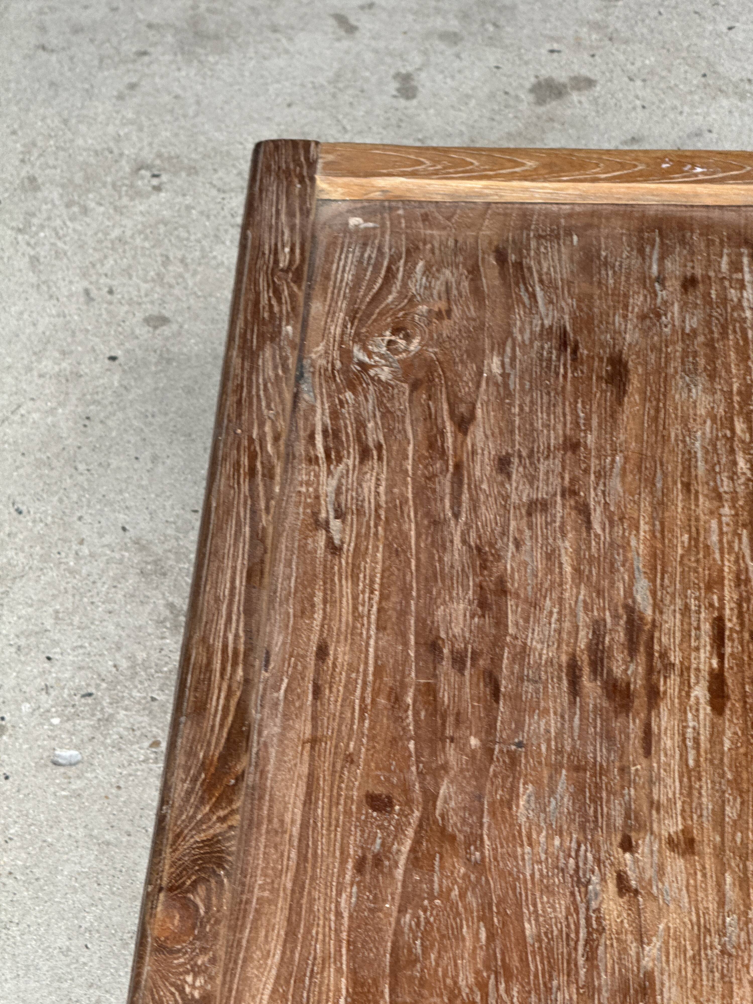 Brown Indonesian teak coffee table, with a border and cylindrical legs H40 L103.