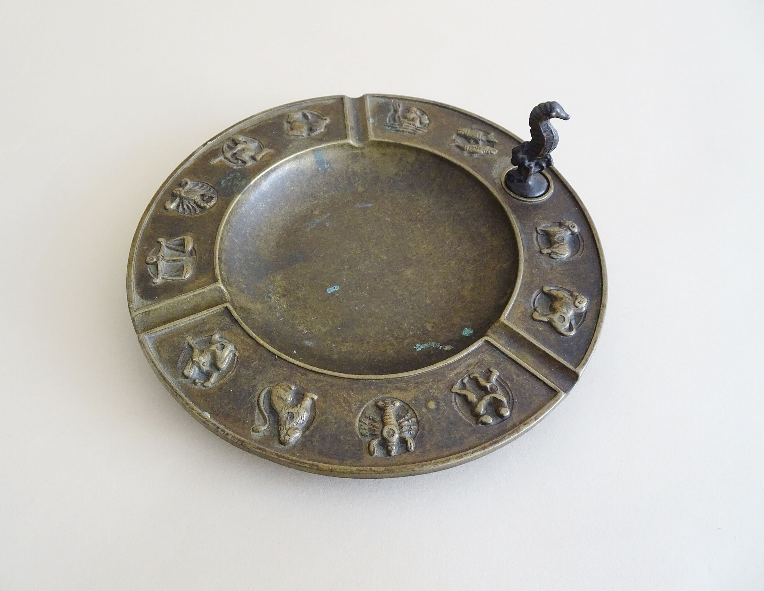 Luxa brass ashtray with zodiac relief and embers killer
