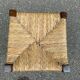 Low stool in brutalist style made of solid wood with straw, 1980.