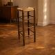 Vintage rustic style bar stool made of solid wood with a straw seat.