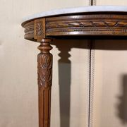Half-moon console in Louis XVI style made of carved wood.
