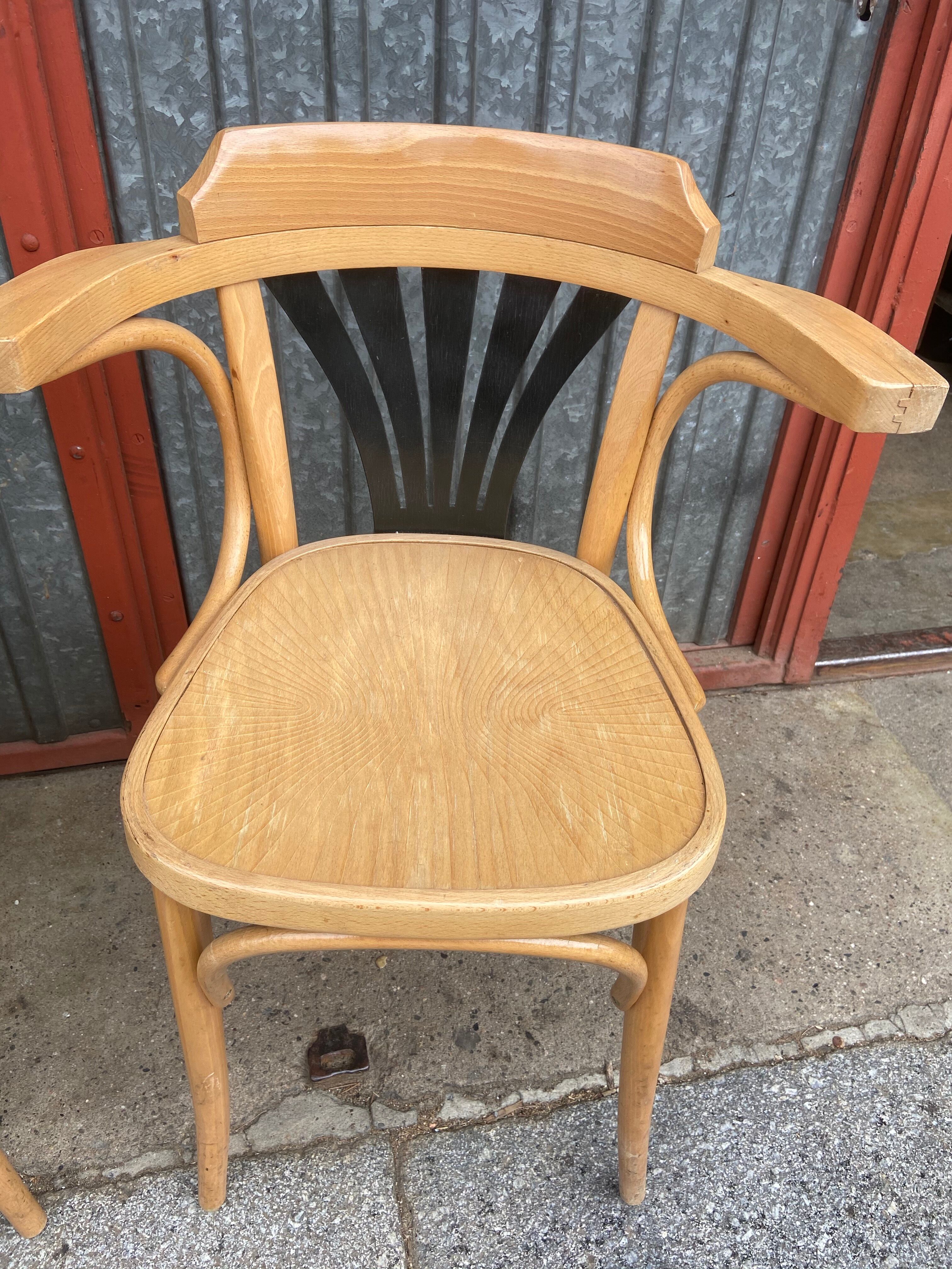Pair of curved wooden bistro chairs with armrests