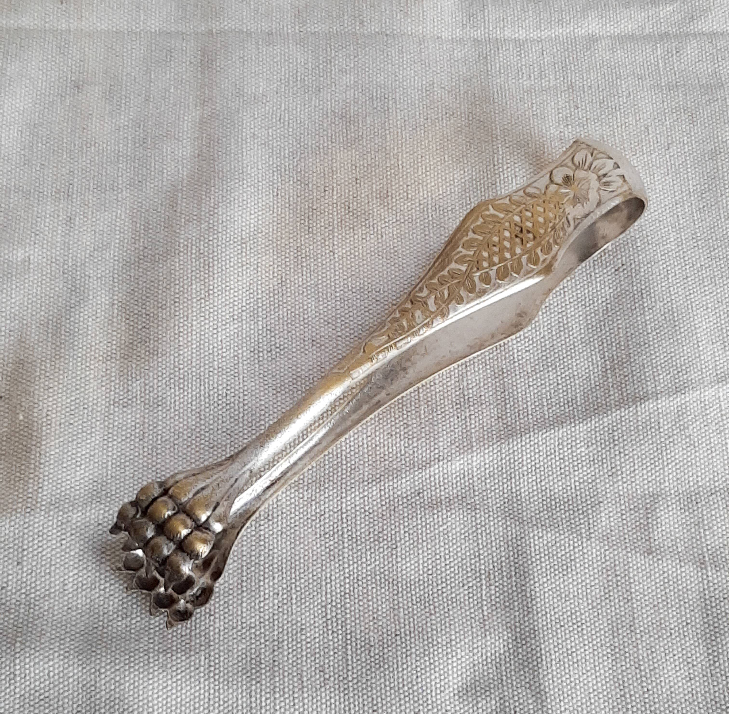 Antique silver-plated sugar tongs with lion's paws.