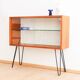 Teak display cabinet with black hairpin legs.