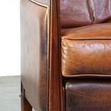 Comfortable Art Deco design armchair in cognac-colored sheepskin combined with wood