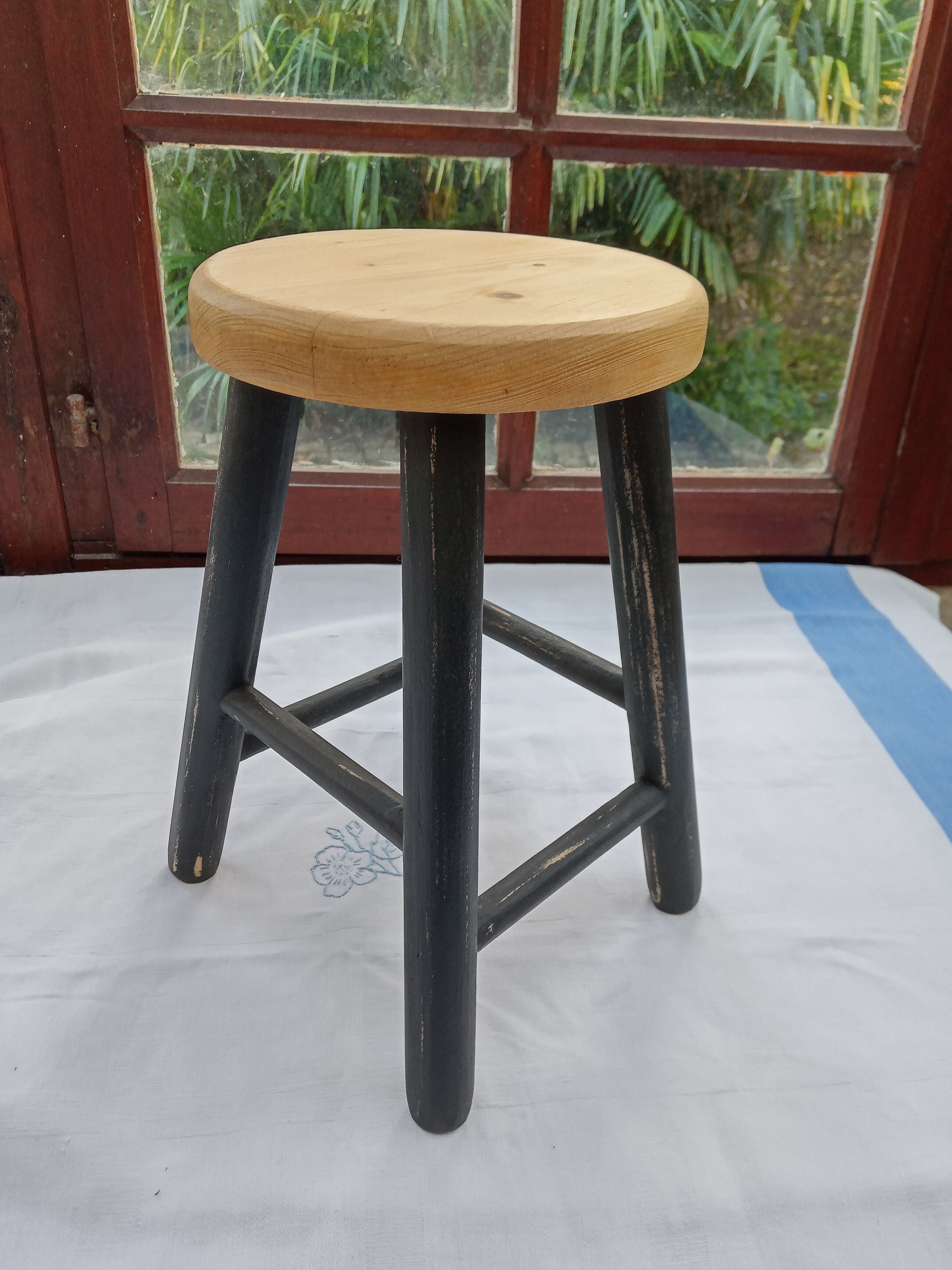 Low wooden stool and black patina