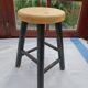 Low wooden stool and black patina