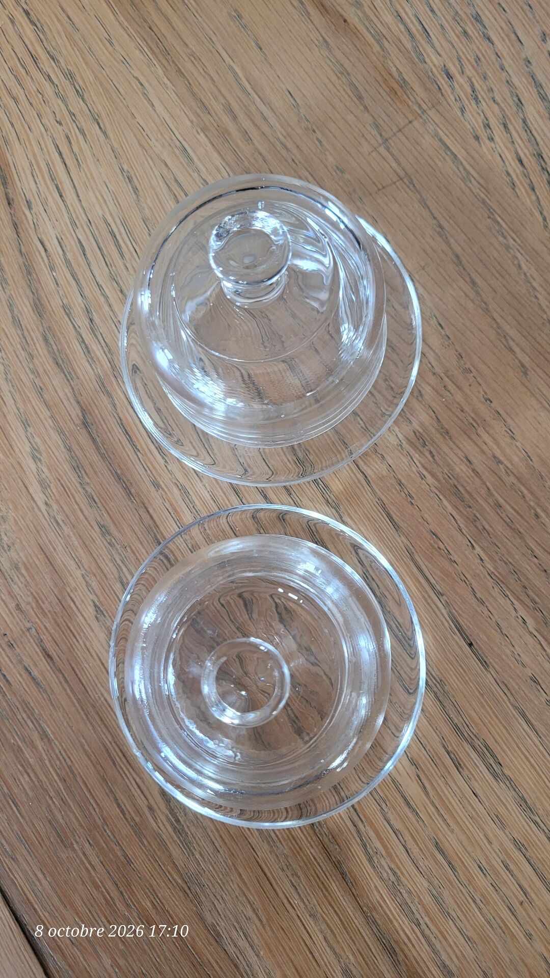 2 transparent glass butter dishes accompanied by their matching cloches.