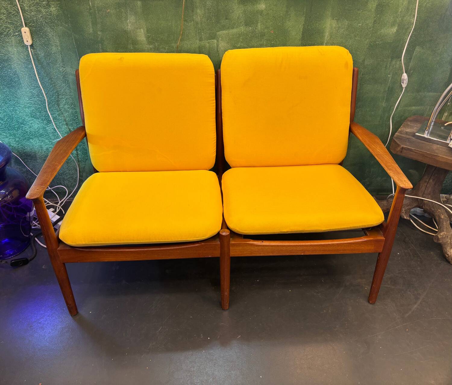 Vintage Scandinavian two-seater bench with mustard yellow cushions.