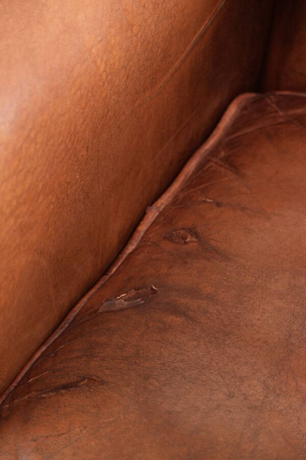 Ensemble de deux fauteuils en peau de mouton vintage ornés de clous décoratifs.