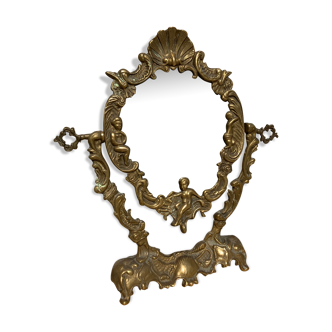 Antique dressing mirror in gilded metal floral moldings and cherub