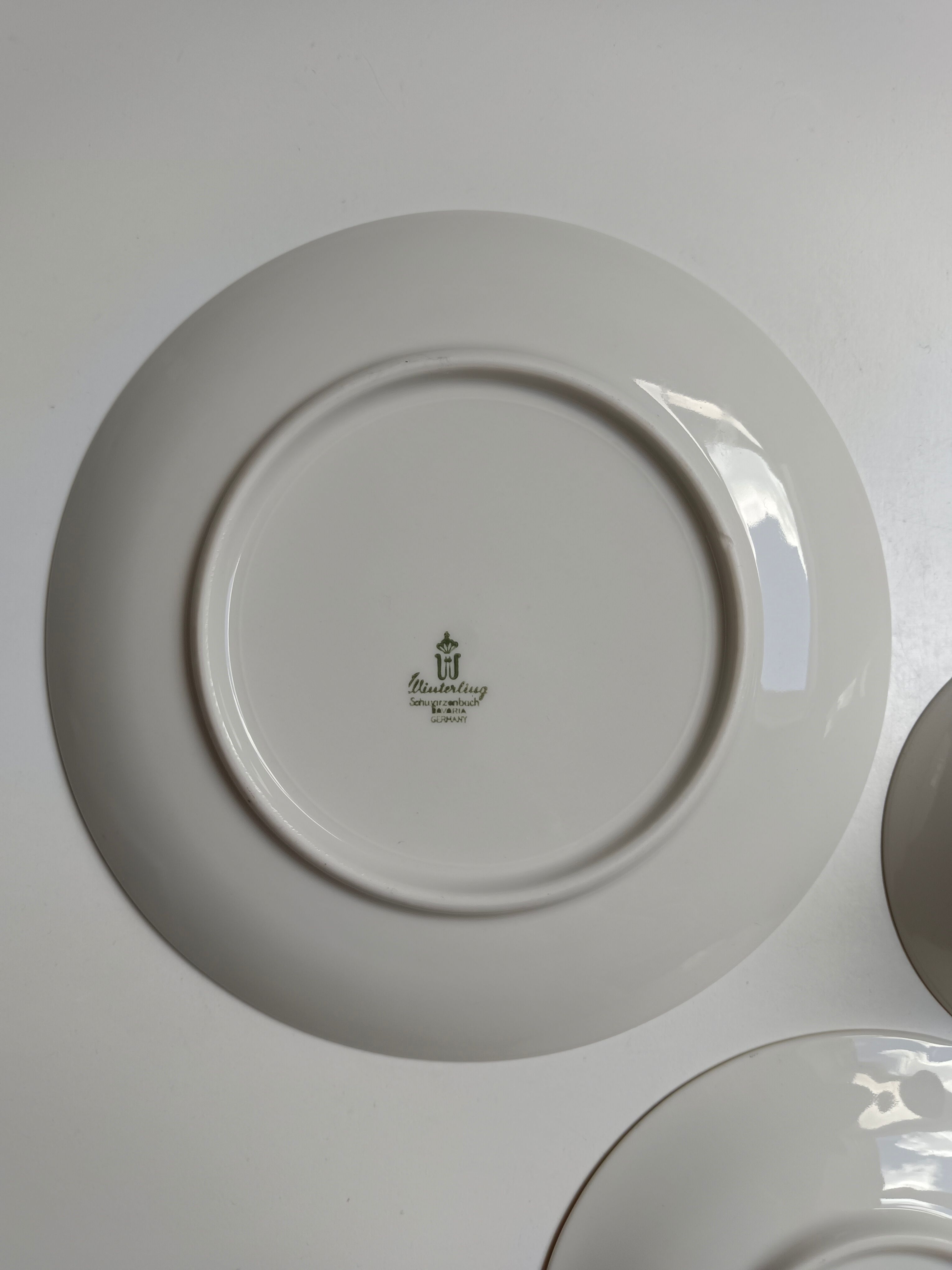 Solitaire tea cup, saucer, and dessert plate in white and gold.