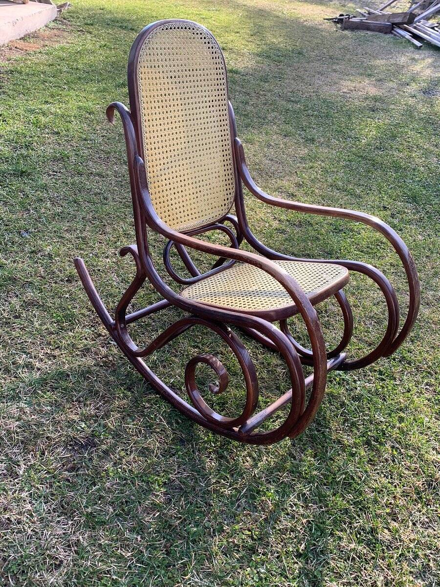 Thonet rocking chair in curved brown wood, period seat, 19th-century bentwood style.