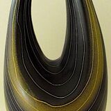 Earthenware vase decorated with yellow lines on a black and yellow background