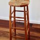 Antique wooden bar stool with a straw seat
