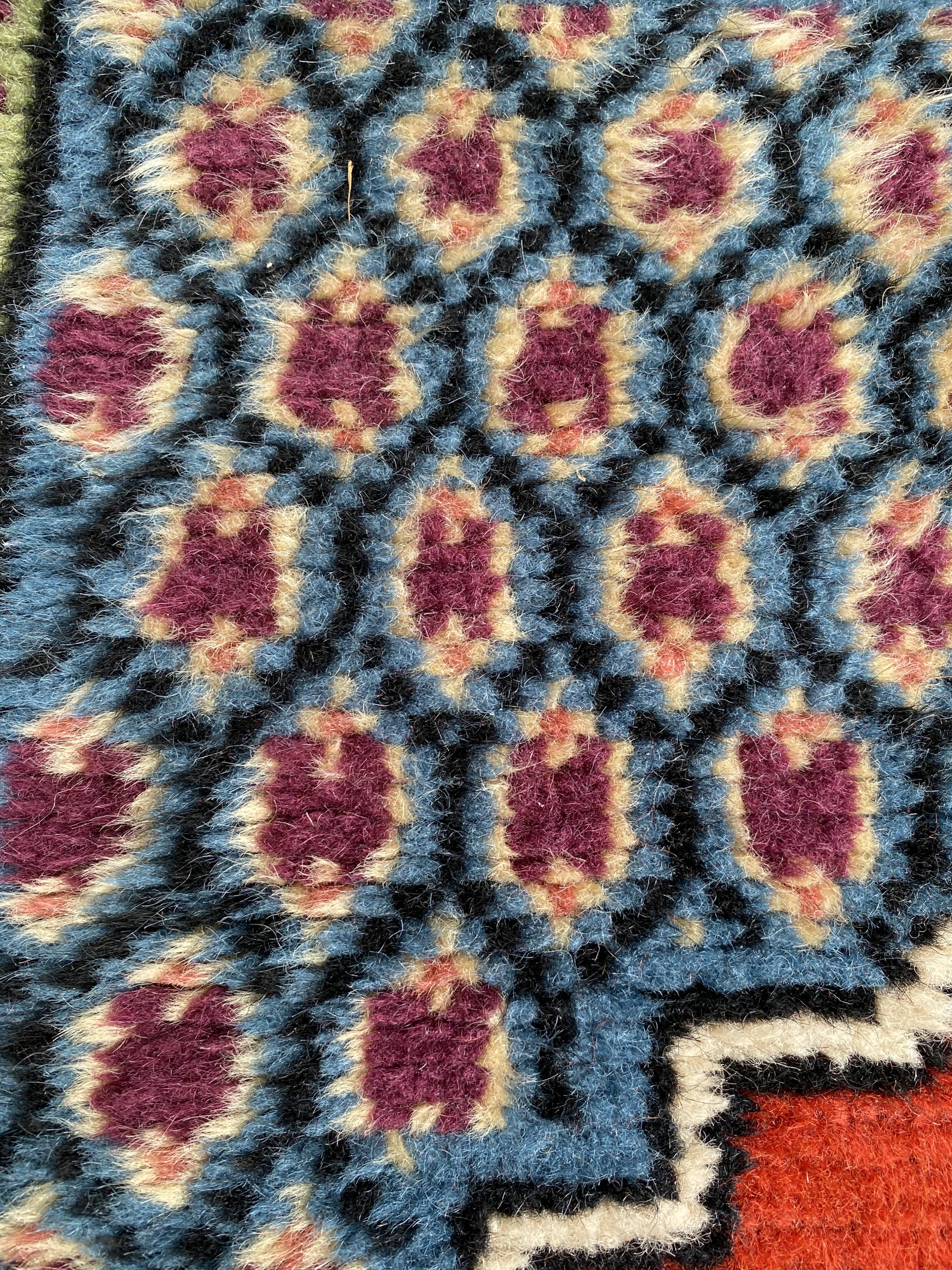 Vintage hand-knotted wool rug with polychrome decoration on a red, blue, green background 150 x 63 cm