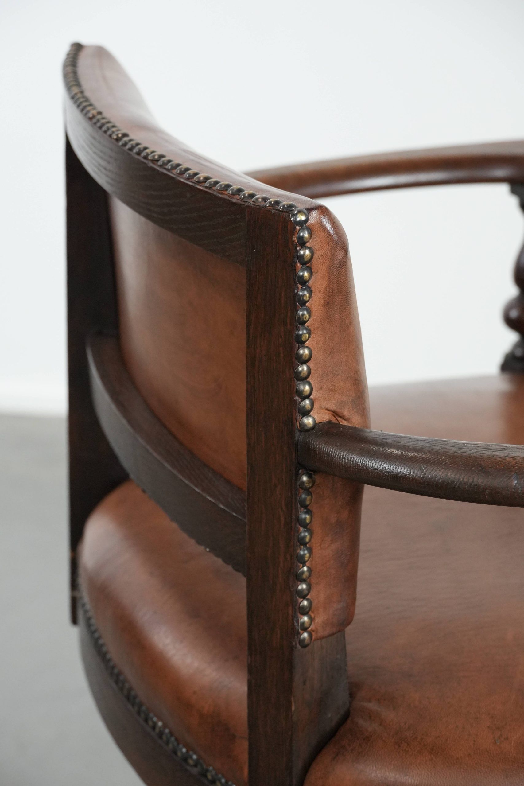 Elegant antique sheepskin leather desk chair with a heavy wooden frame
