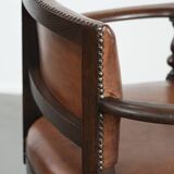 Elegant antique sheepskin leather desk chair with a heavy wooden frame