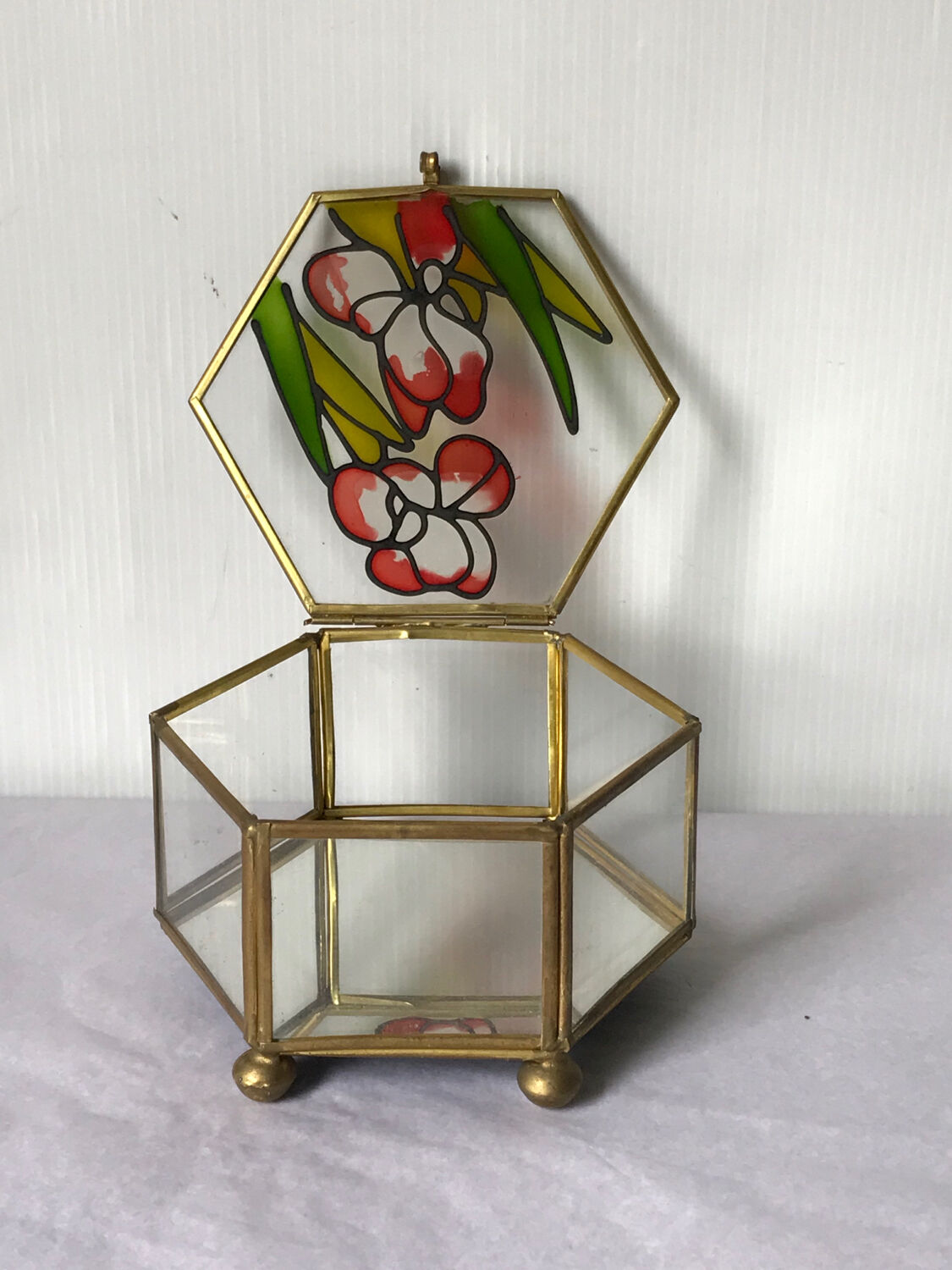 Glass box and hexagonal brass enamelled floral decoration