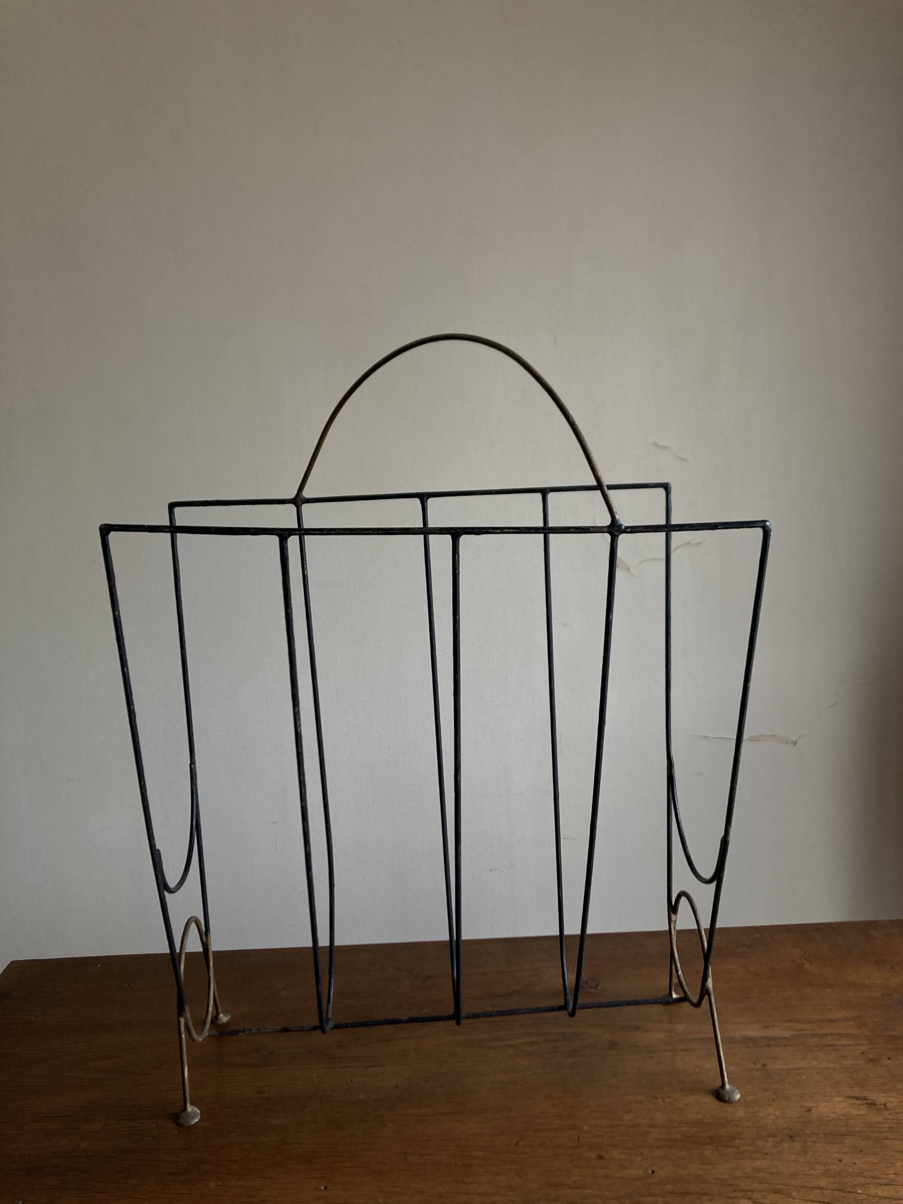Mid-century poetic magazine rack in black metal