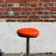 Vintage chrome stool with orange faux leather.