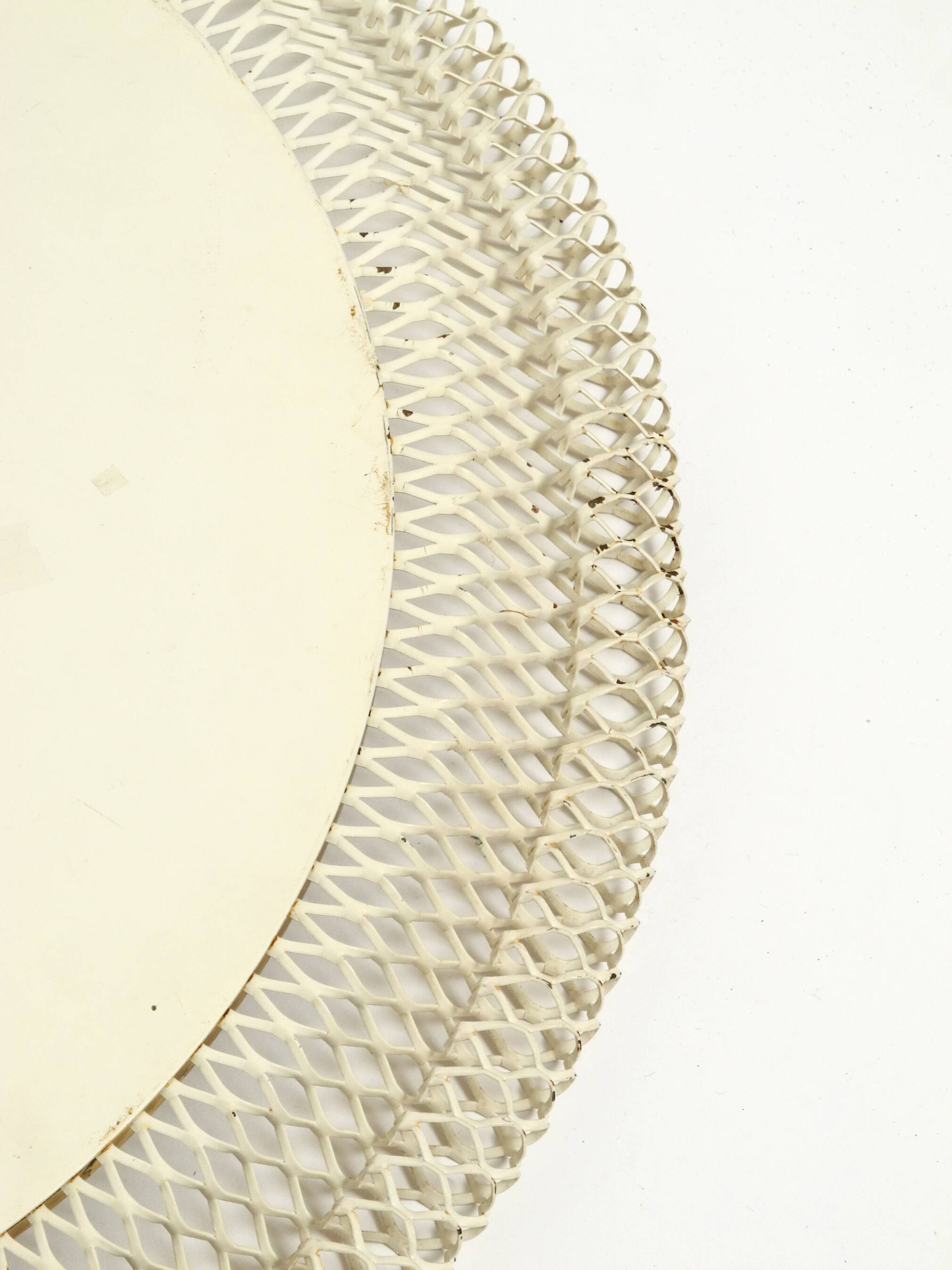 Mid Century Modern round wall mirror with a white expanded metal frame