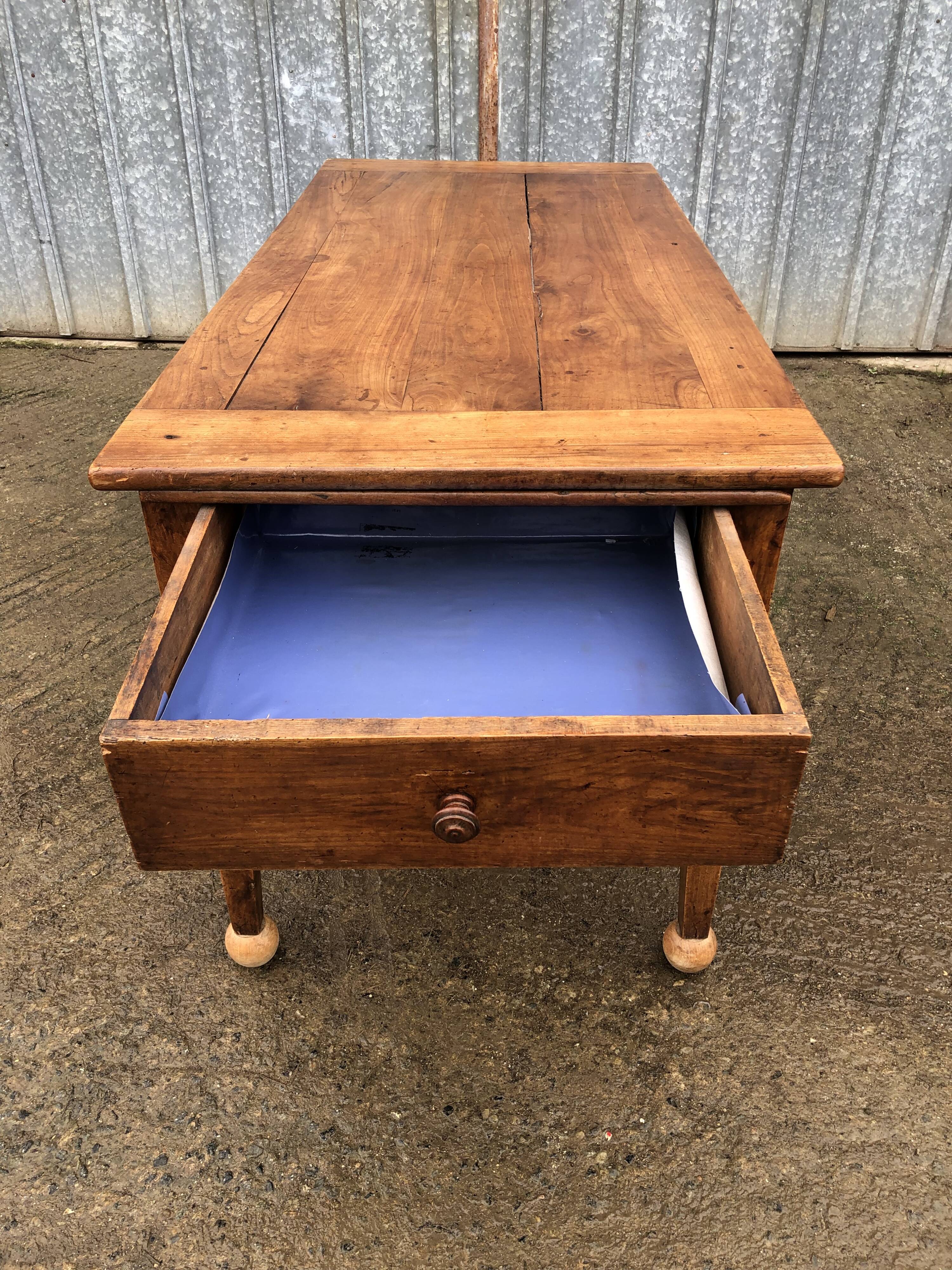 Antique solid cherry farmhouse table with 2 end drawers and 1 pull-out.