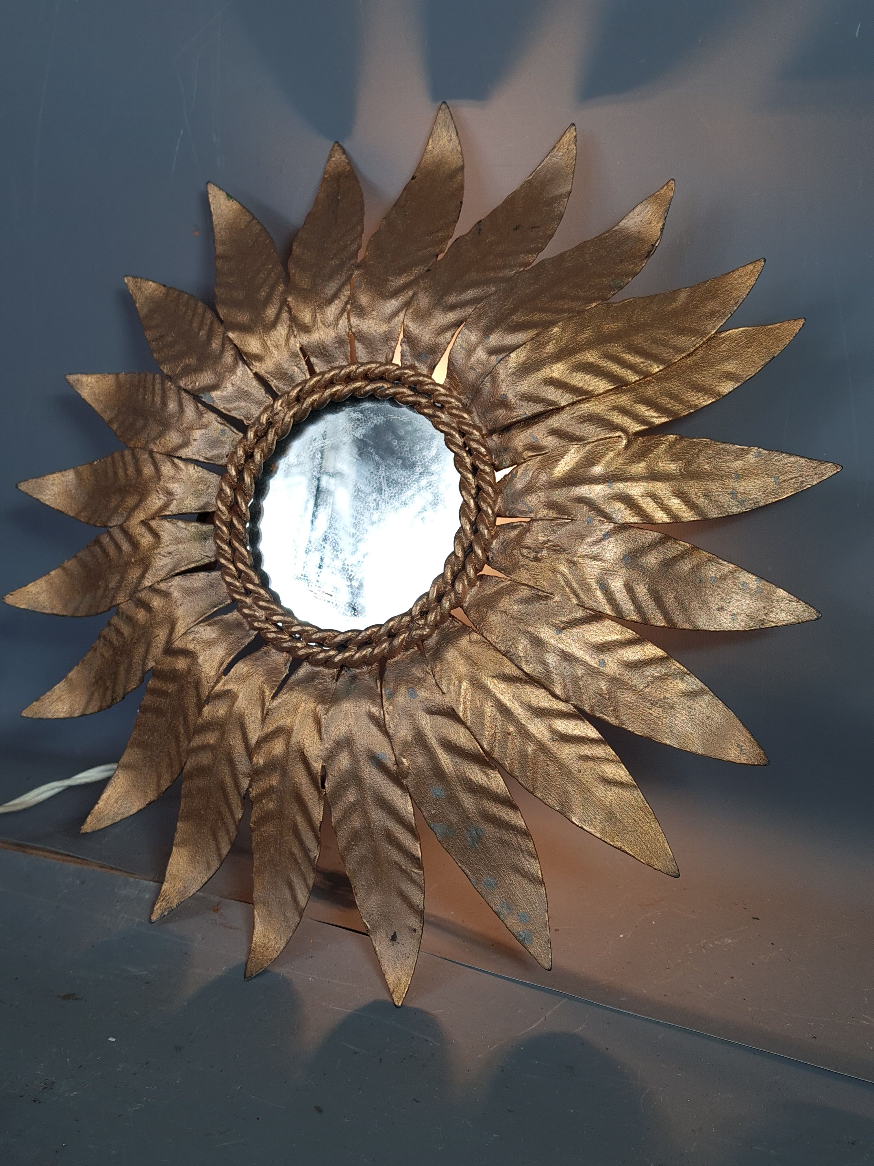 Wall lamp forming sun in gilded brass and with a mirror. Vintage 50s.