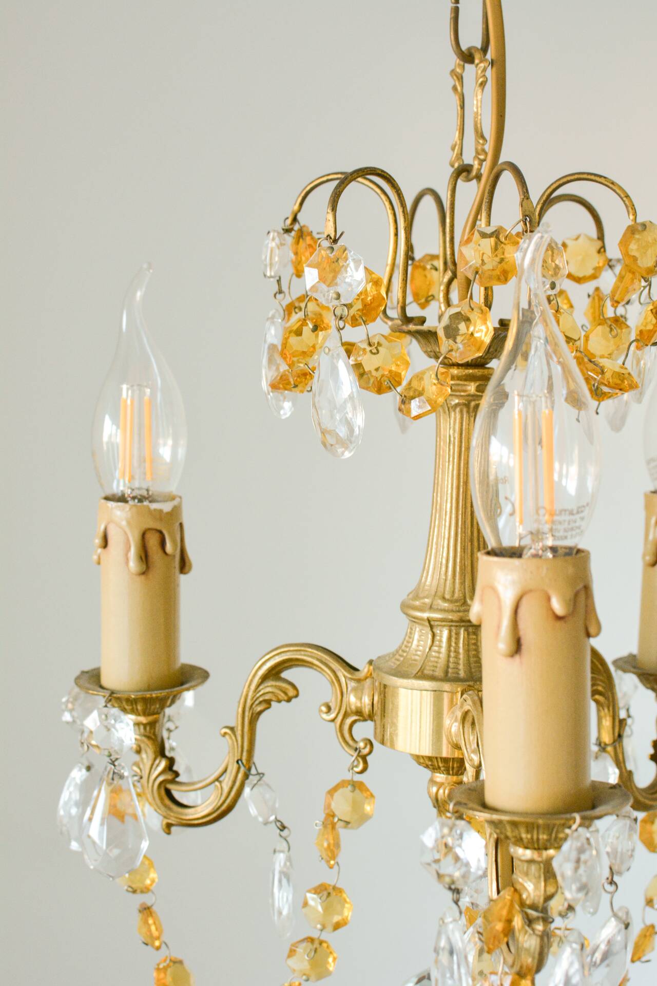 Small vintage brass chandelier with amber crystal pendants.