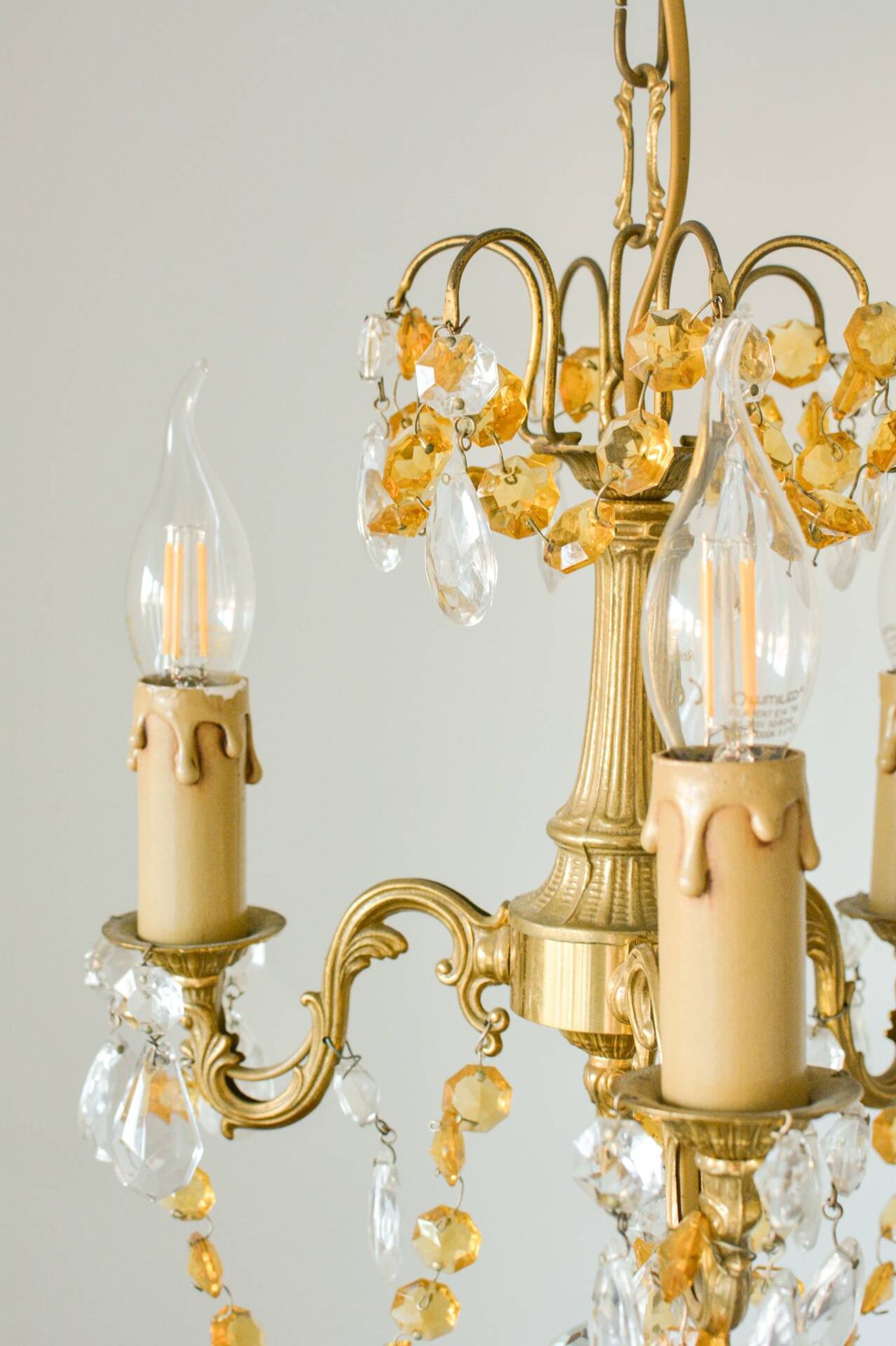 Small vintage brass chandelier with amber crystal pendants.