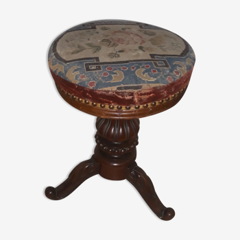 Old dark wooden piano stool covered in pretty fabric