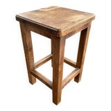 Brutalist stool in raw wood with a weathered effect.