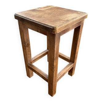 Brutalist stool in raw wood with a weathered effect.
