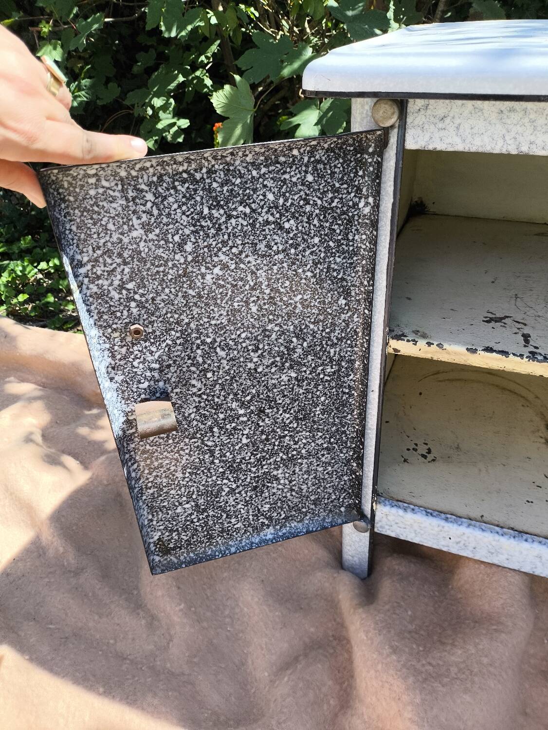 Small white and speckled gray industrial style enameled piece of furniture