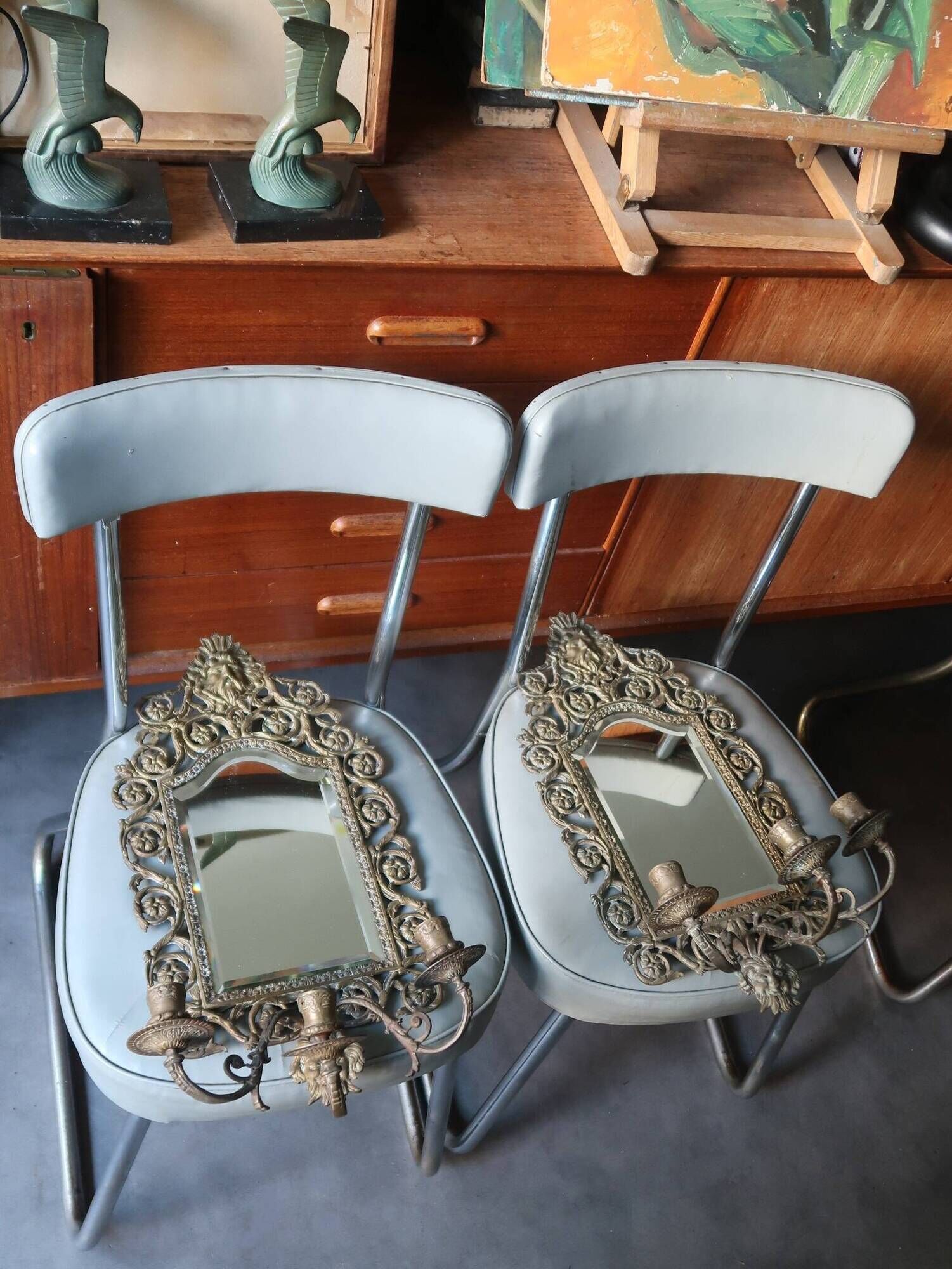 Pair of mirror wall sconces with brass candle holders.
