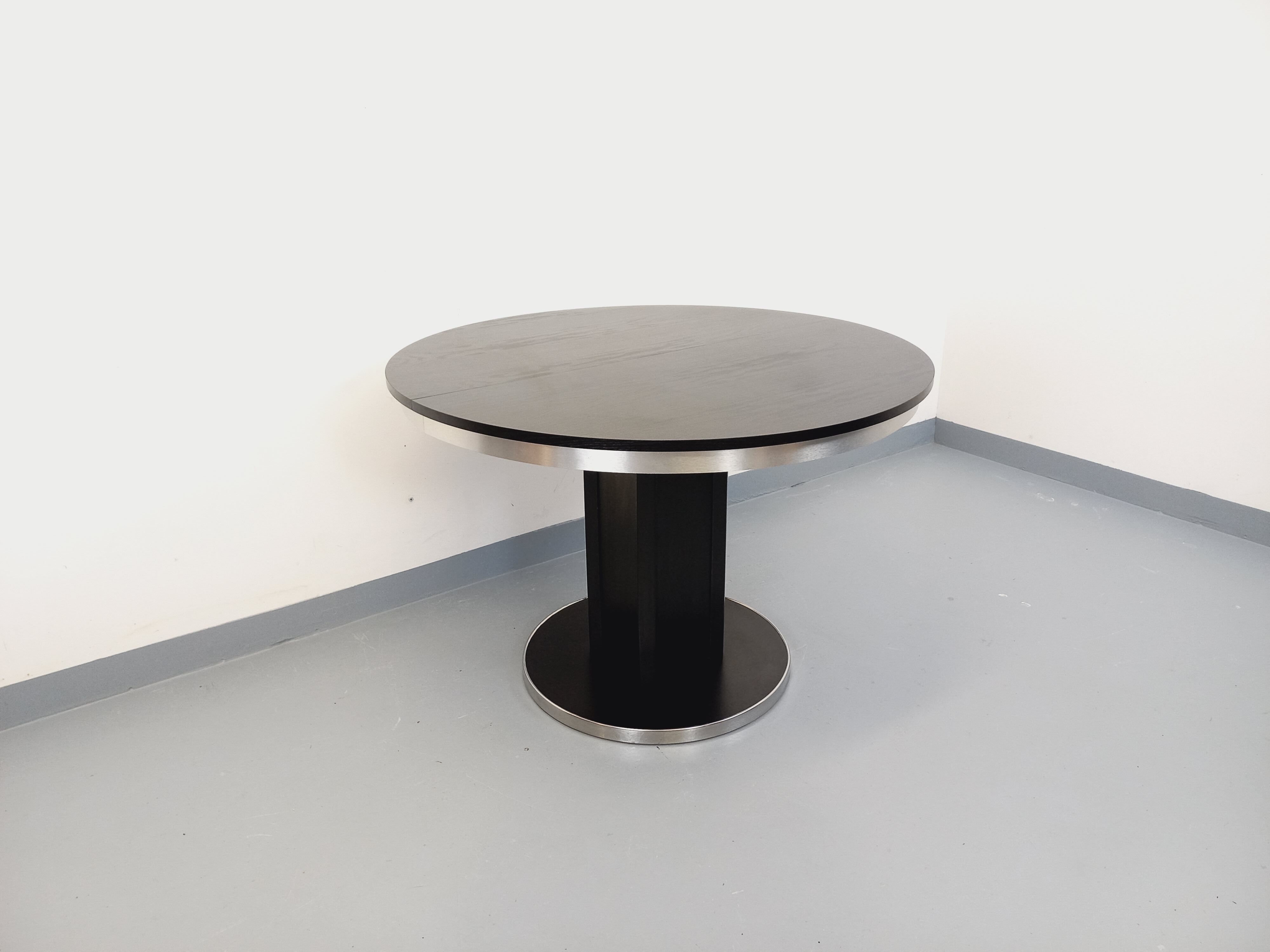 Vintage dining table in melamine with a black wood effect and chrome metal.