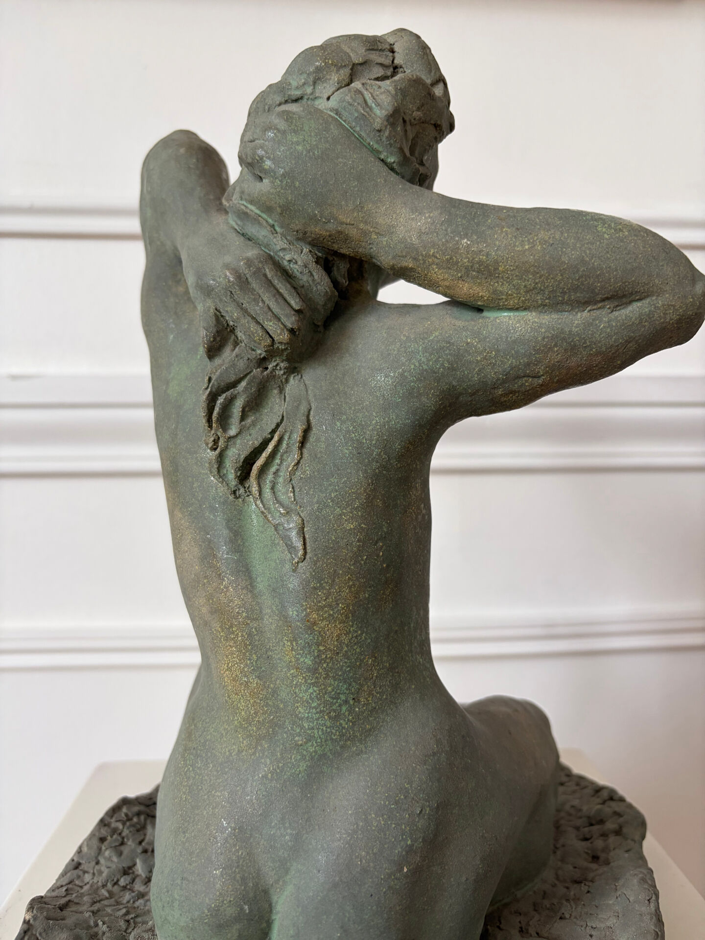 Sculpture of a naked woman titled "Youth" in terracotta.