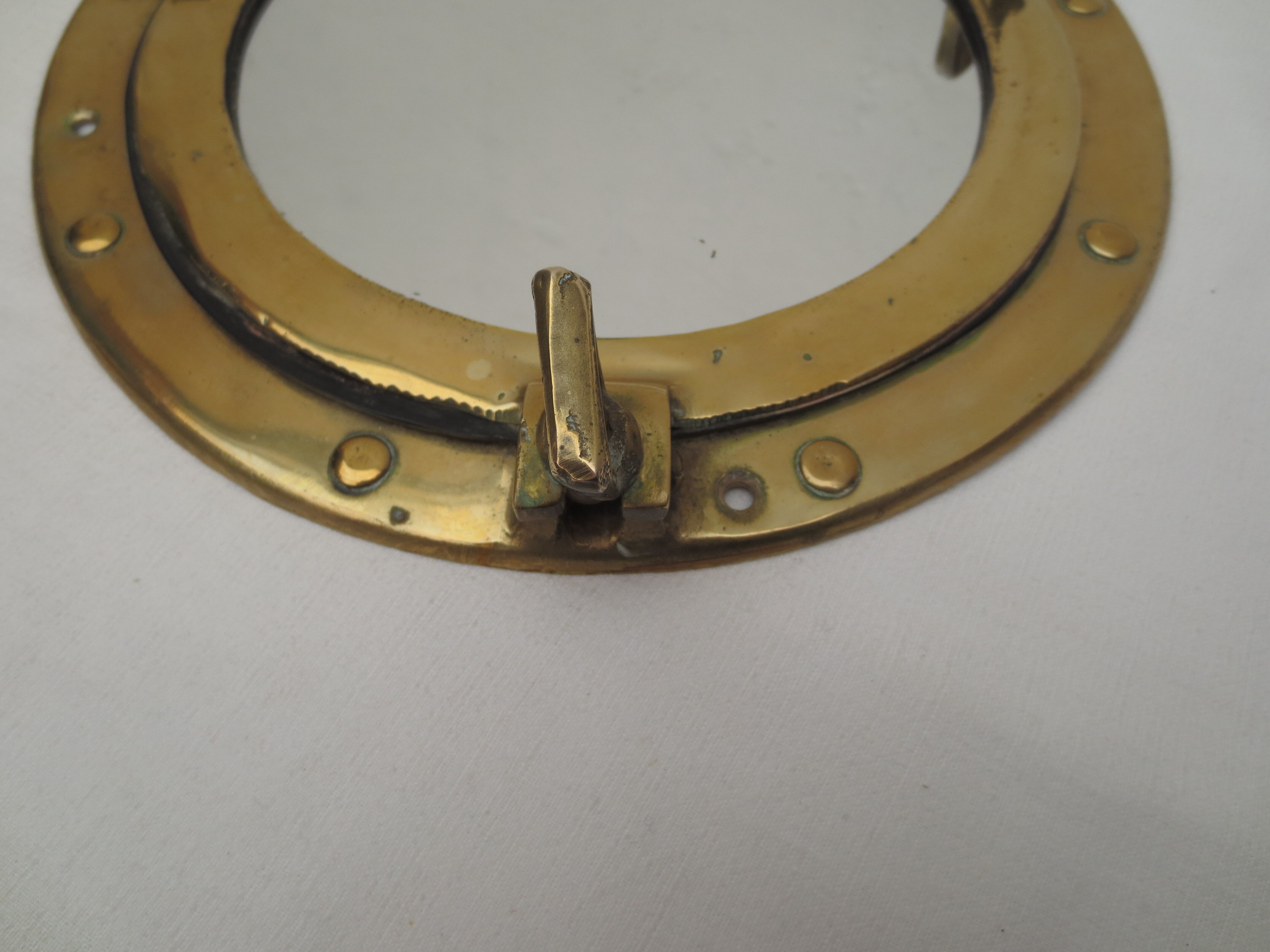 Mirror integrated into a brass navy porthole