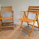 Pair of varnished wooden folding armchairs signed Clairitex.