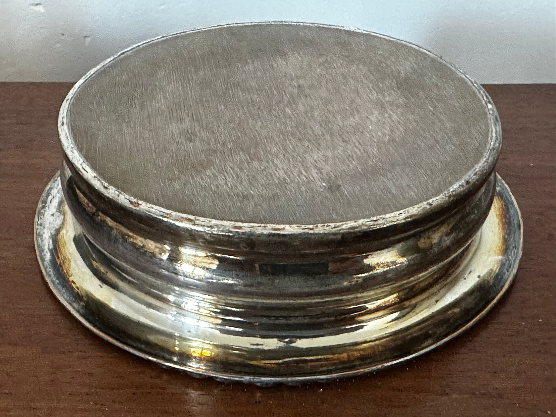 Antique silver-plated bottle coaster with floral decoration.