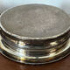 Antique silver-plated bottle coaster with floral decoration.