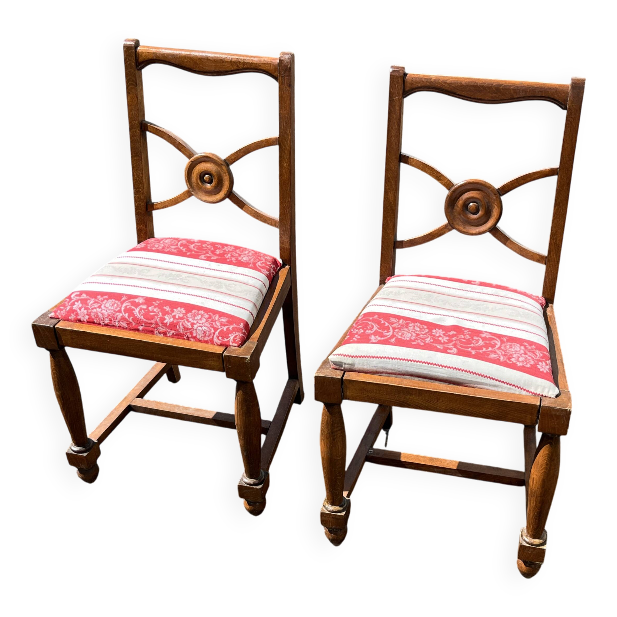 Pair of antique walnut chairs with rose design and red striped cushions.