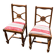 Pair of antique walnut chairs with rose design and red striped cushions.