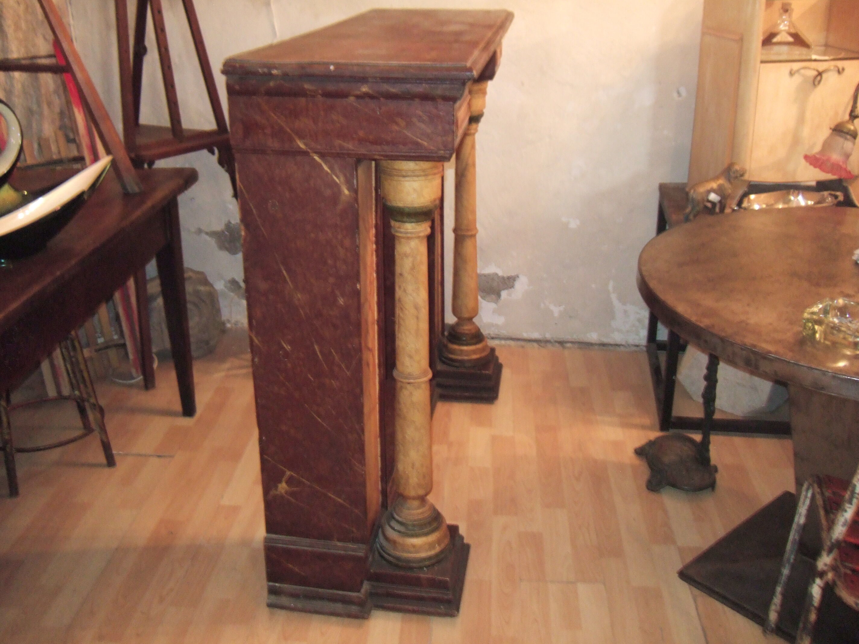 19th century wooden fireplace, faux marble paint. Can act as a console.