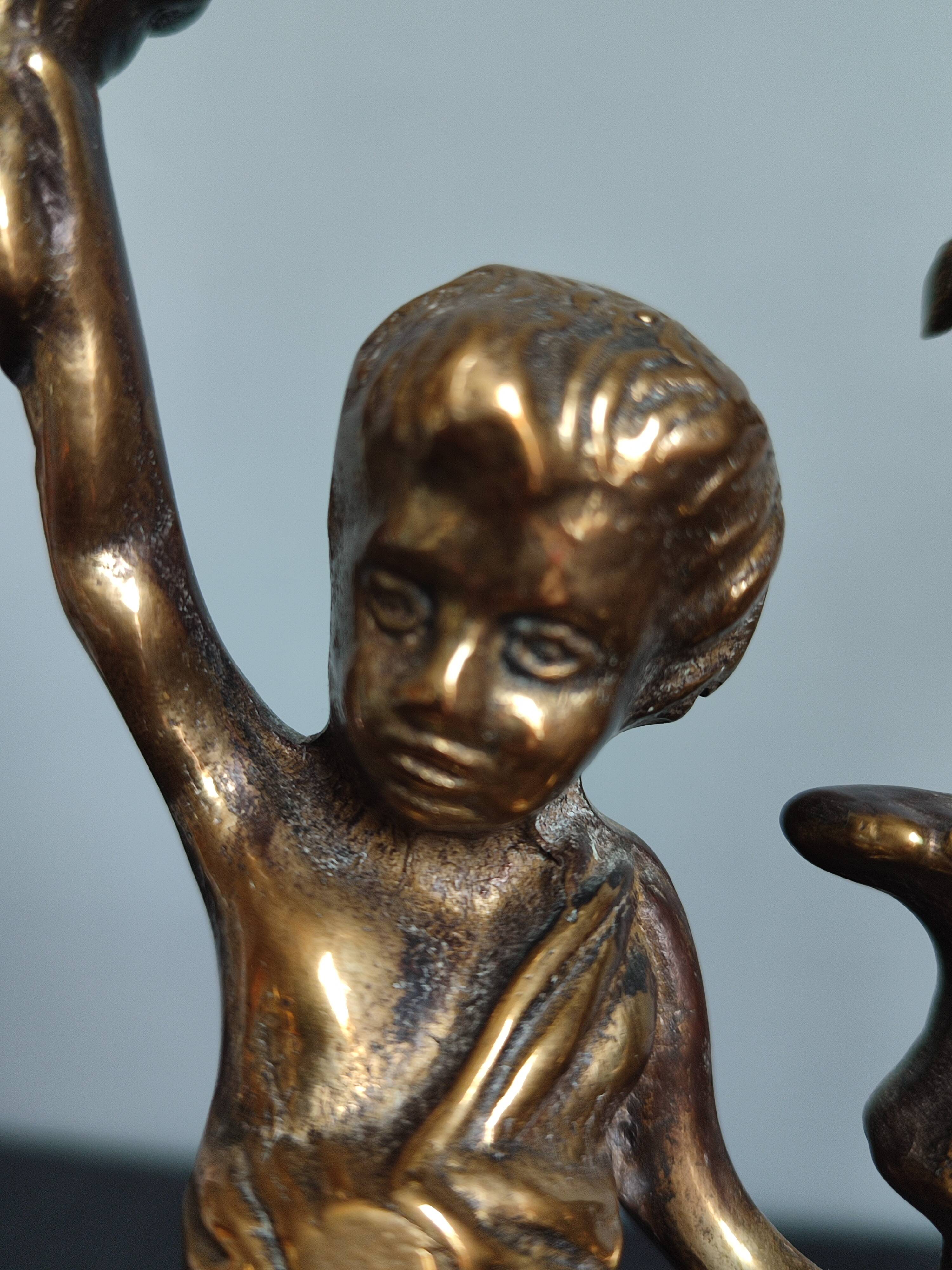 Pair of antique candlesticks in cherub bronze