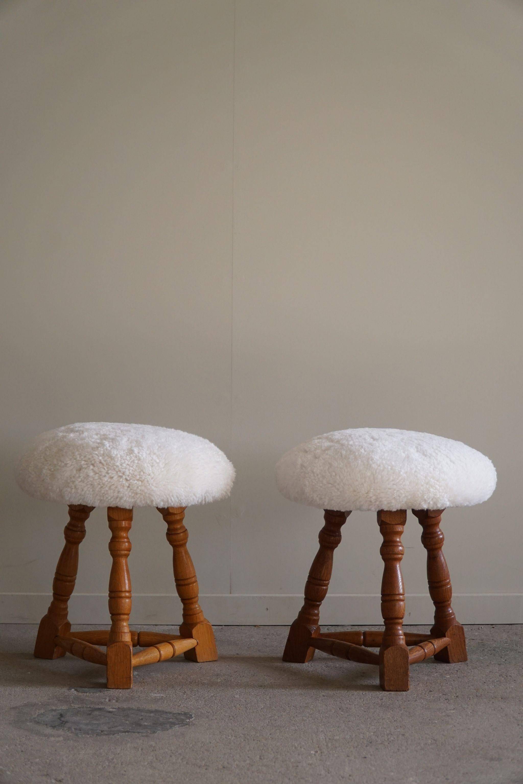 Modern Danish, a pair of tripod stools, seats reupholstered in lambswool, 1950s.